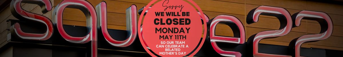Neon storefront sign with a pink circular notice: 'Sorry we will be closed Monday May 11th… belated Mother's Day'